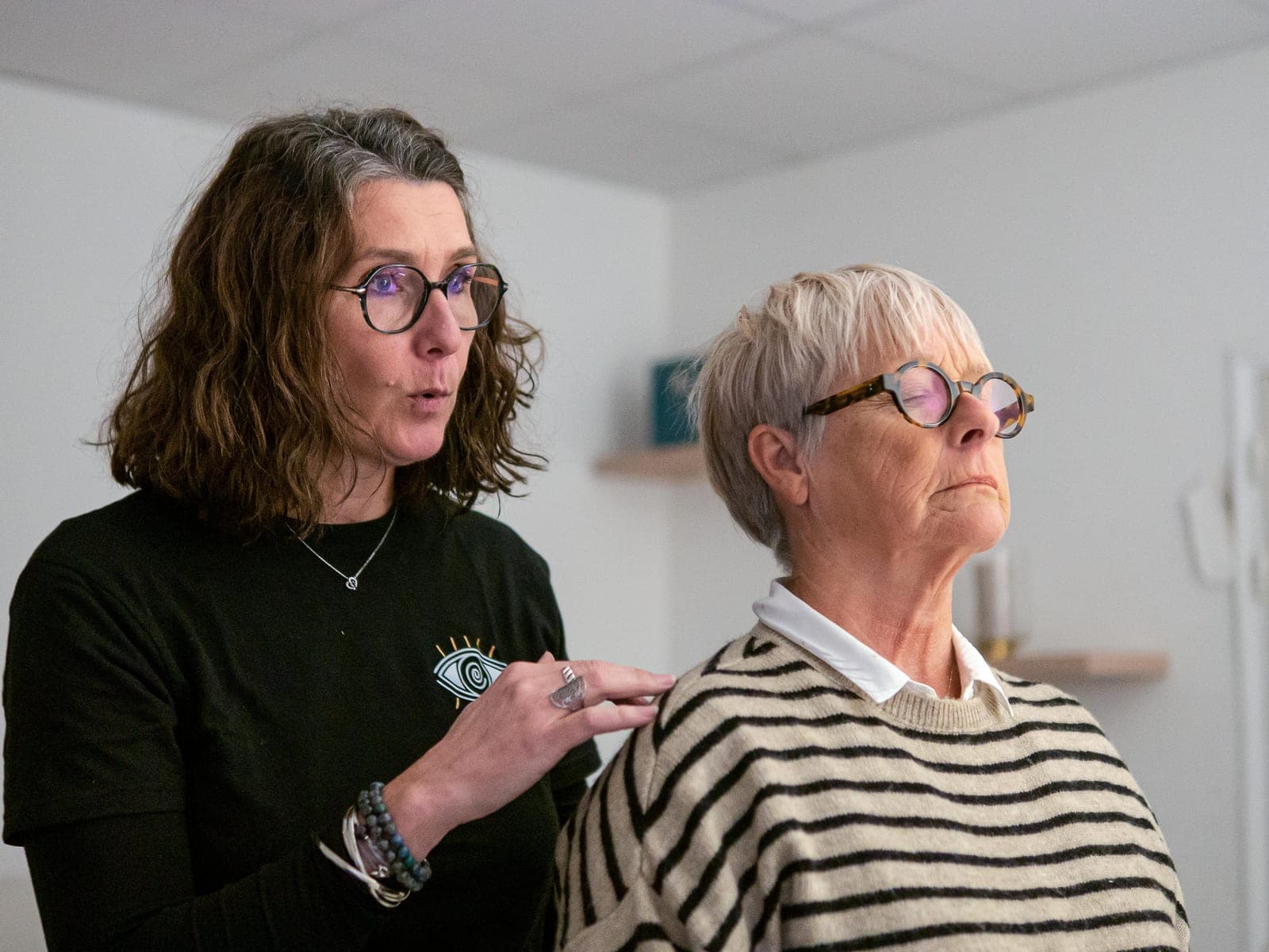 Fanny Autret, la main posée sur l'épaule d'une personne accompagnée, pendant une séance au cabinet.